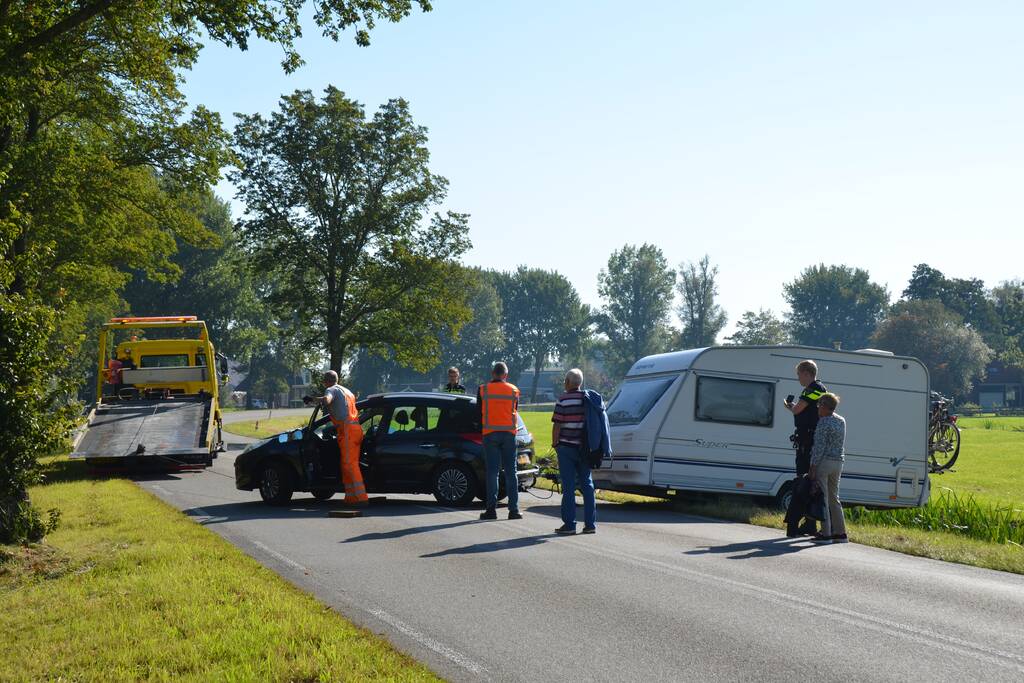 Auto met caravan raakt van de weg