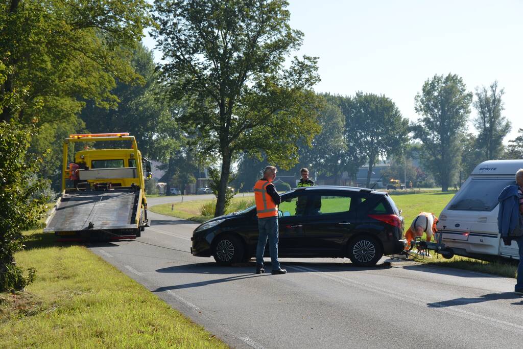 Auto met caravan raakt van de weg