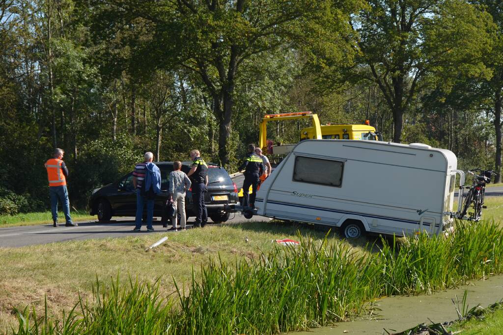 Auto met caravan raakt van de weg