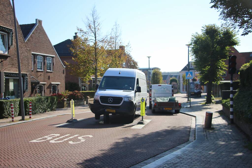 Bestelbus komt vast te zitten op paal van bussluis