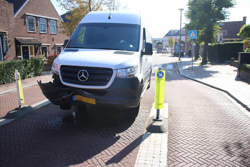Bestelbus komt vast te zitten op paal van bussluis
