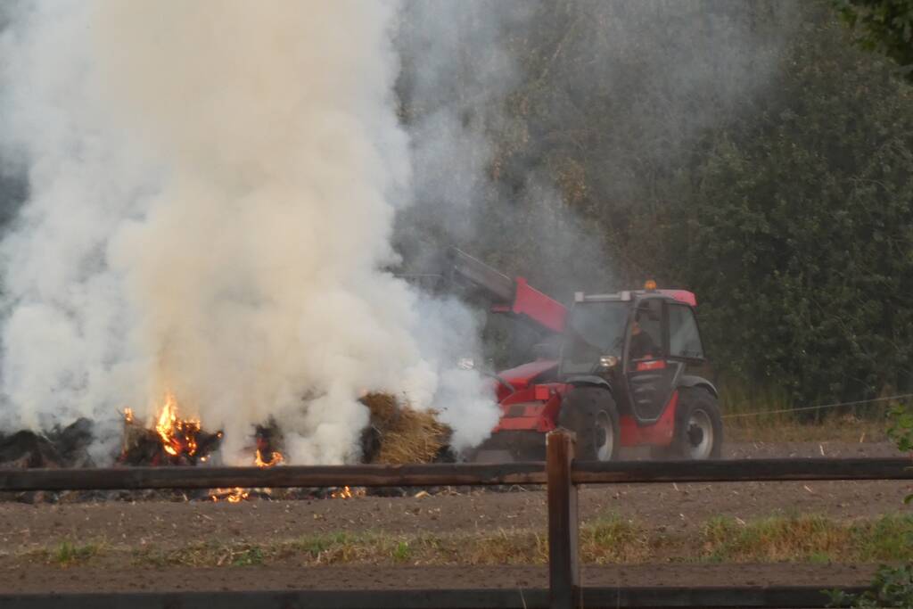 Brandende hoop hooi zorgt voor veel rookontwikkeling