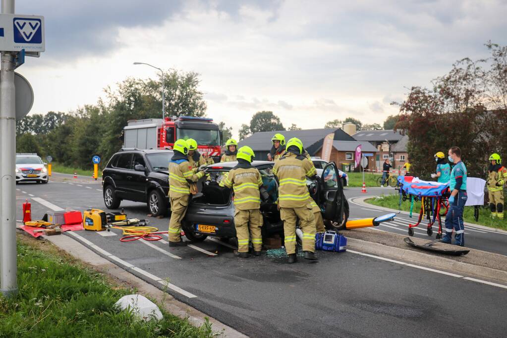 Vrouw bekneld in voertuig bij aanrijding op kruising