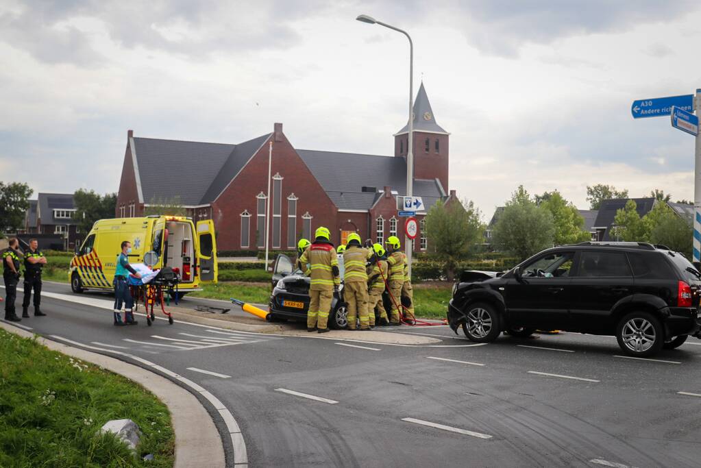 Vrouw bekneld in voertuig bij aanrijding op kruising