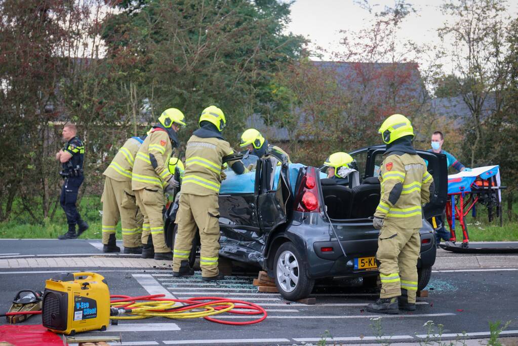 Vrouw bekneld in voertuig bij aanrijding op kruising