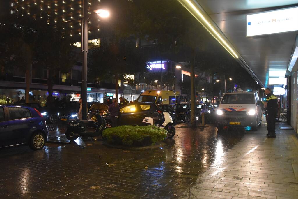 Scooterrijder valt met scooter tegen auto