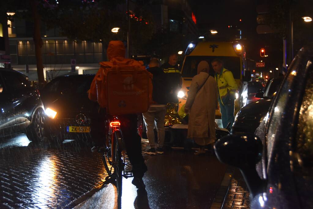 Scooterrijder valt met scooter tegen auto