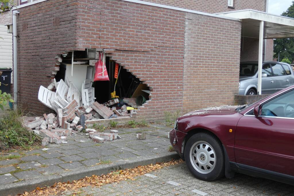 Automobilist rijdt garage in bij wegrijden
