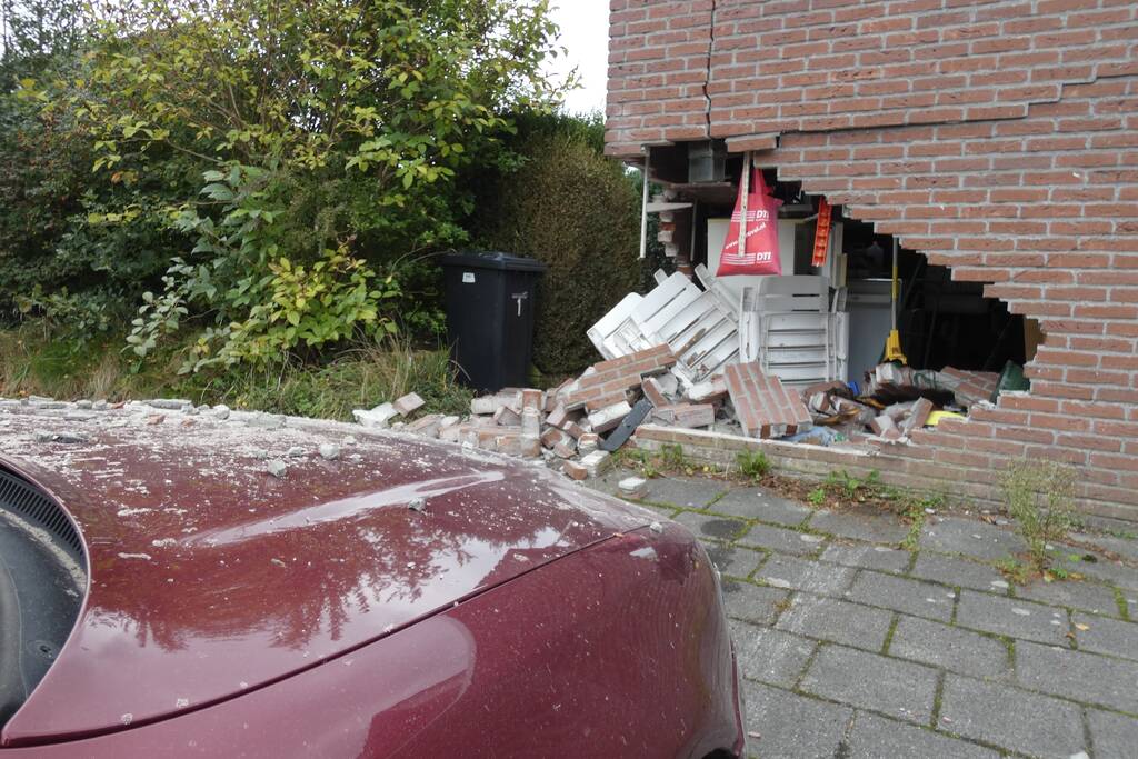 Automobilist rijdt garage in bij wegrijden