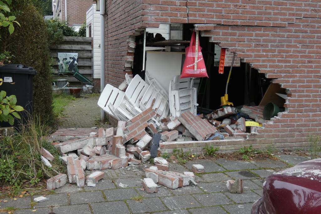 Automobilist rijdt garage in bij wegrijden