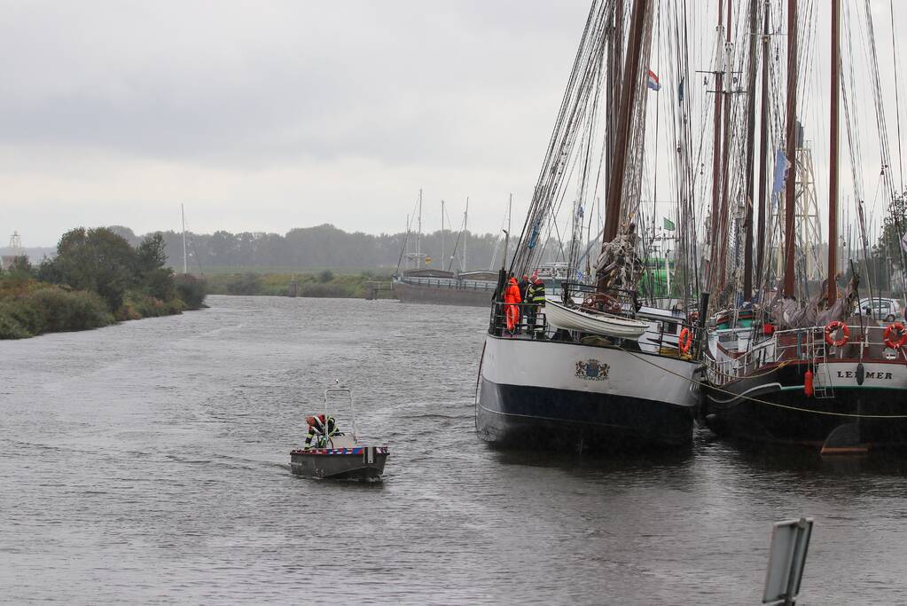 Brandweer plaats olieschermen voor lekkend zeilschip