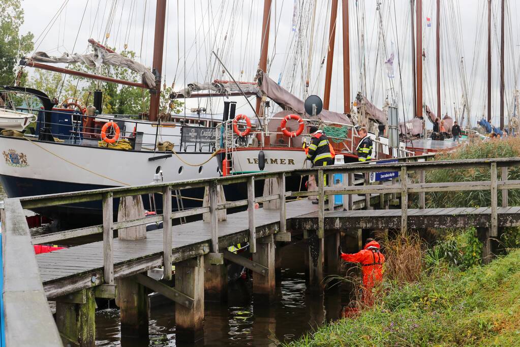 Brandweer plaats olieschermen voor lekkend zeilschip