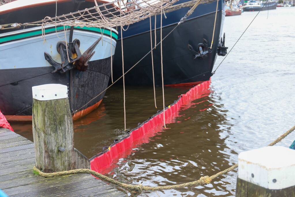 Brandweer plaats olieschermen voor lekkend zeilschip