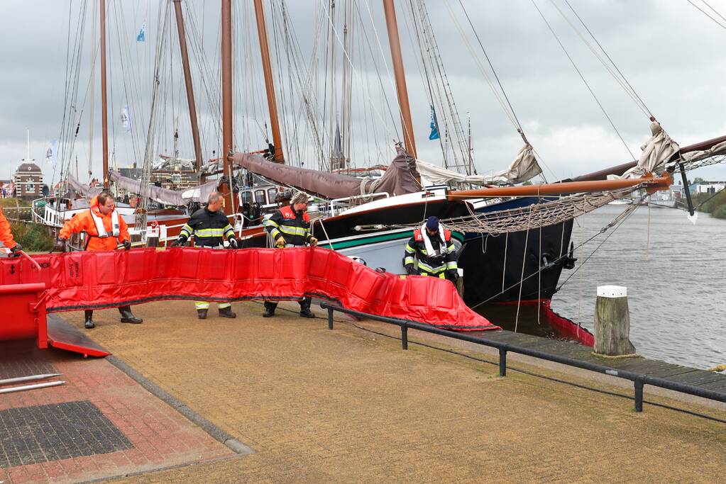 Brandweer plaats olieschermen voor lekkend zeilschip