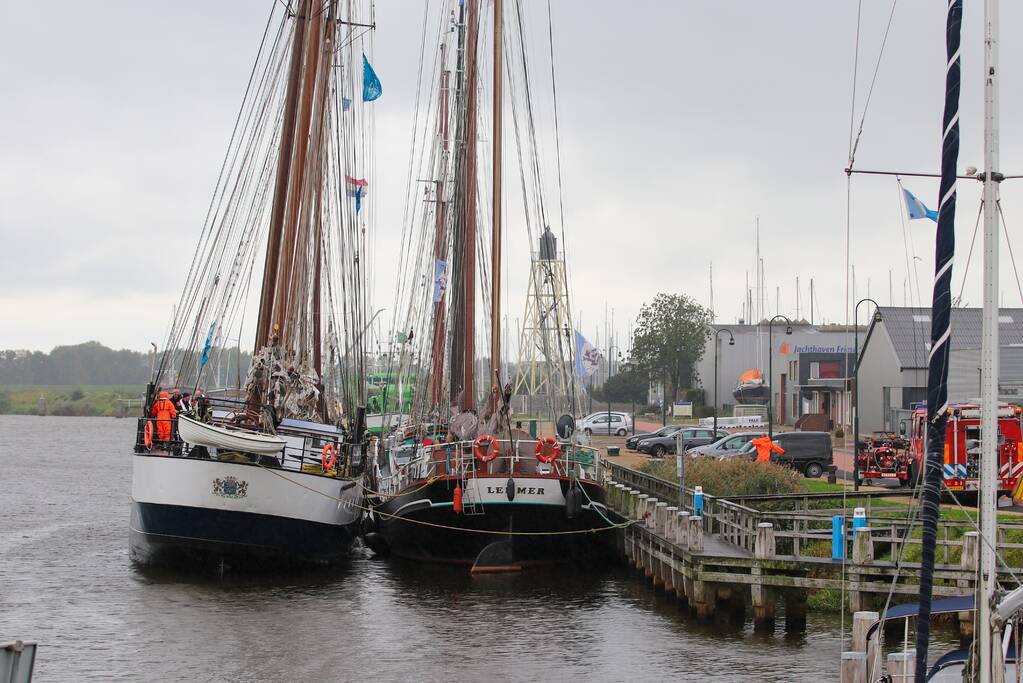 Brandweer plaats olieschermen voor lekkend zeilschip