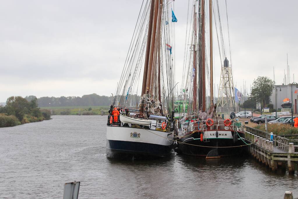 Brandweer plaats olieschermen voor lekkend zeilschip