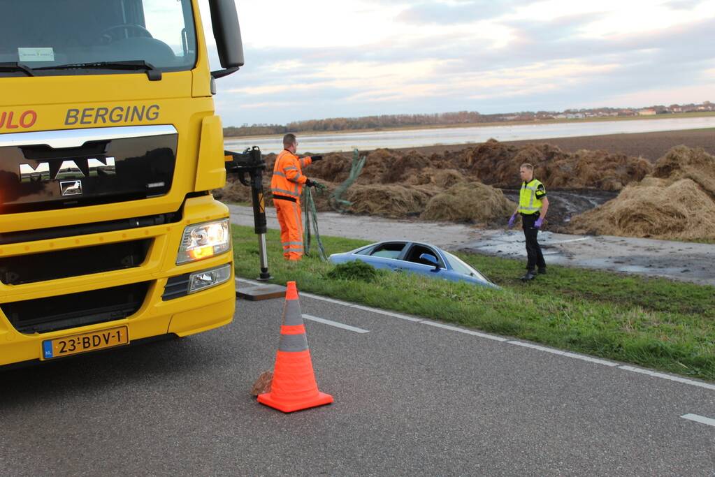 Personenauto raakt steen en rijdt het water in