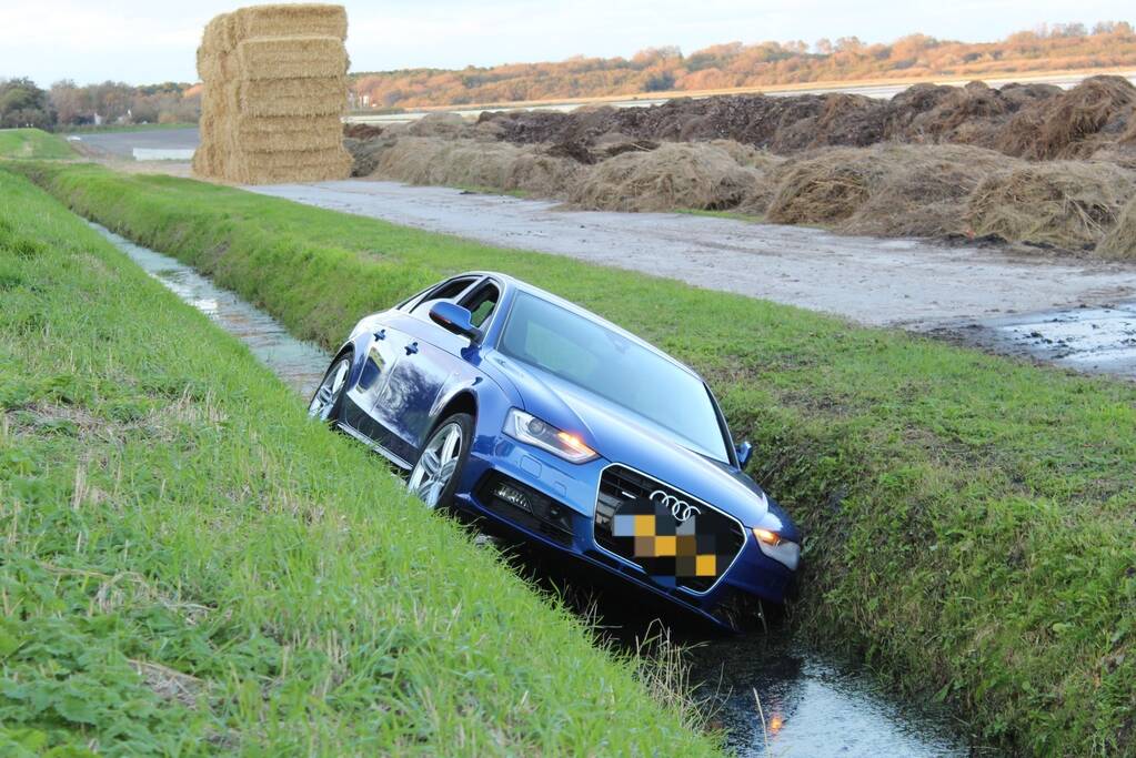 Personenauto raakt steen en rijdt het water in