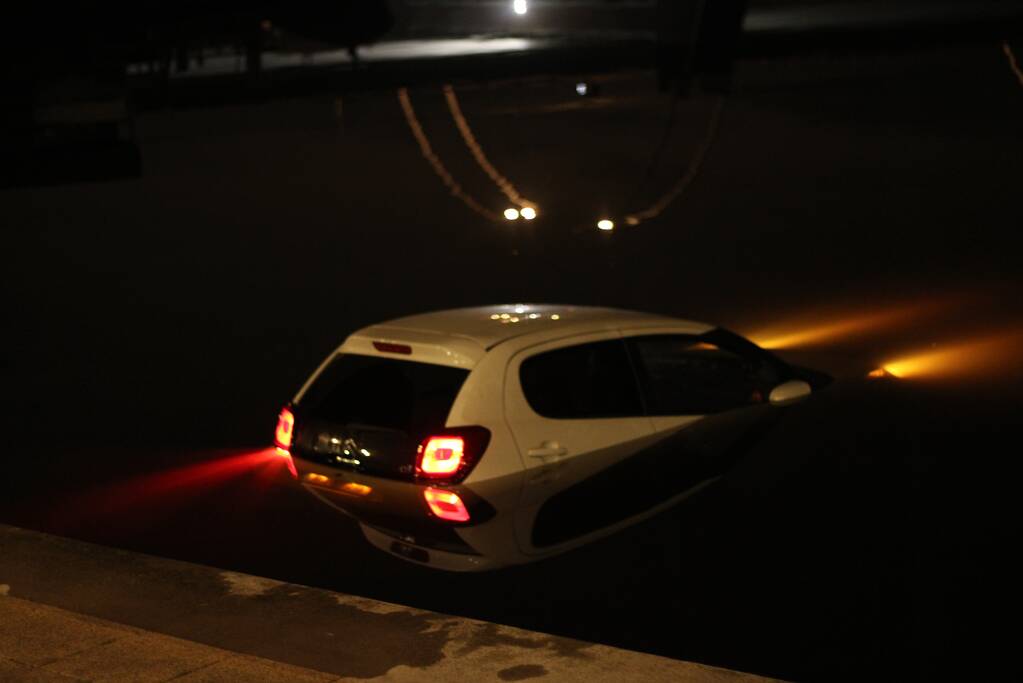 Personenauto rijdt het Spaarne in