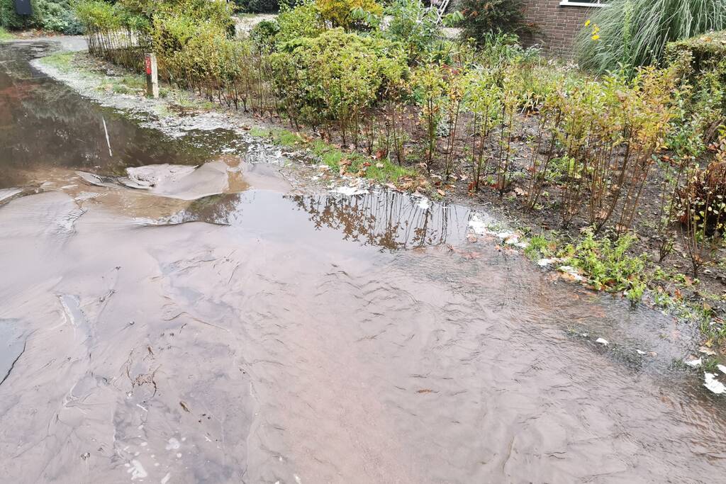 Straat onder water door gesprongen waterleiding