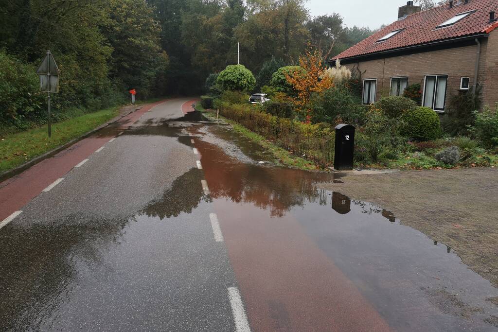 Straat onder water door gesprongen waterleiding