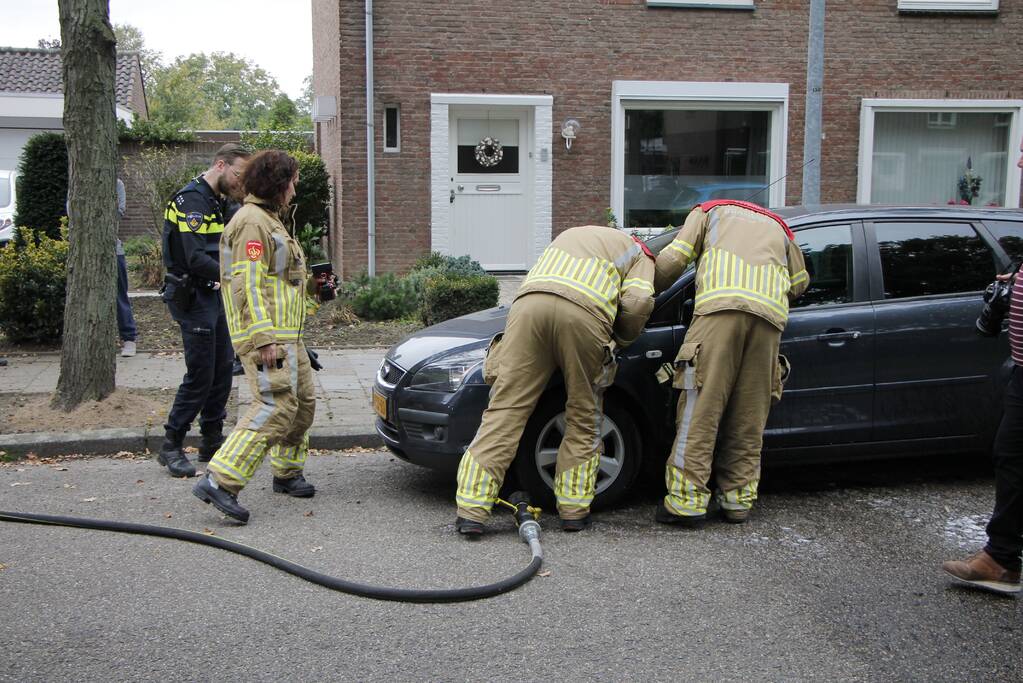 Brandweer blust brand in motorkap