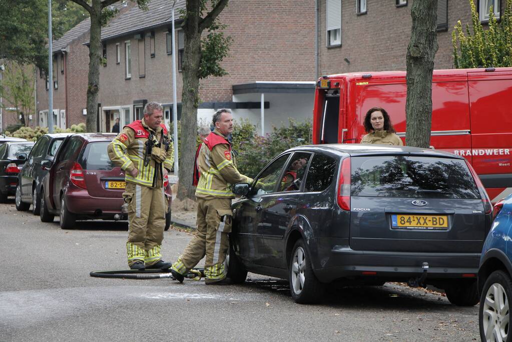 Brandweer blust brand in motorkap