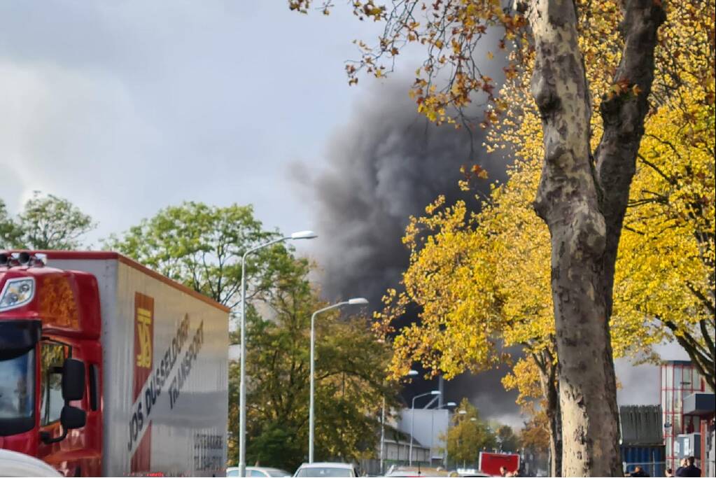 Dikke rookwolken boven industrieterrein bij brand in pand Sims Lifecycle Services
