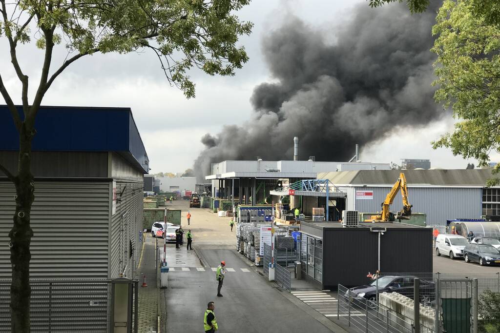 Dikke rookwolken boven industrieterrein bij brand in pand Sims Lifecycle Services