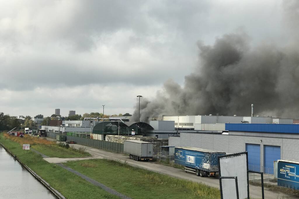 Dikke rookwolken boven industrieterrein bij brand in pand Sims Lifecycle Services