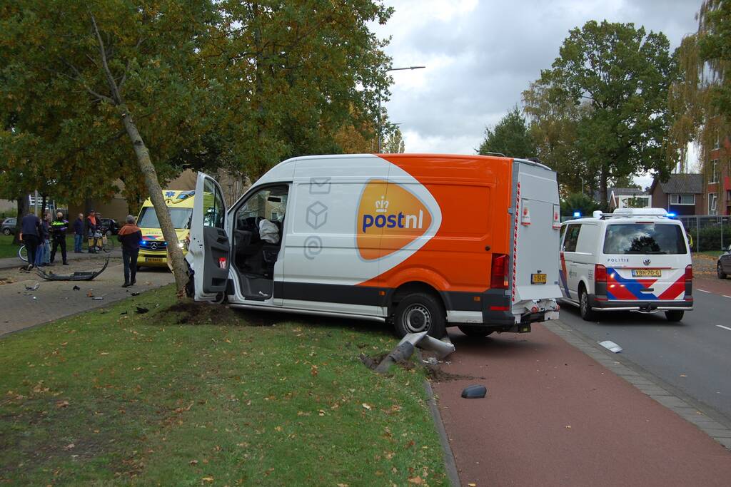 Bestelbus Postnl belandt met hoge snelheid tegen boom