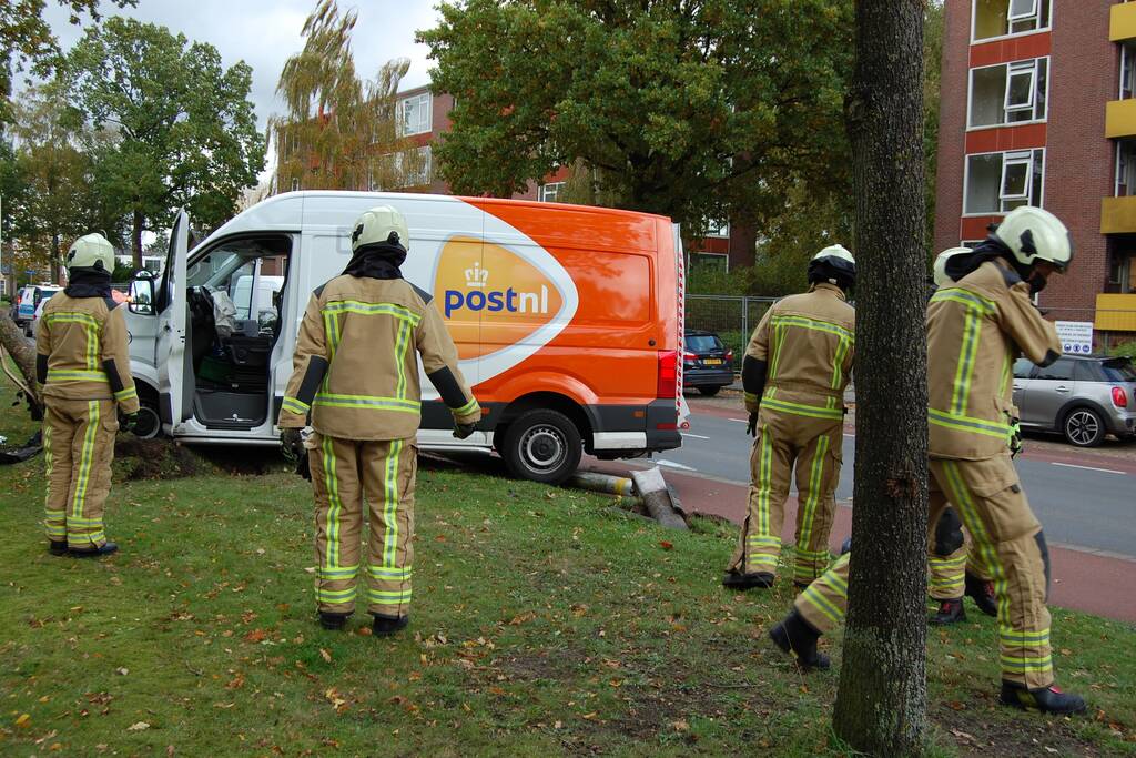 Bestelbus Postnl belandt met hoge snelheid tegen boom