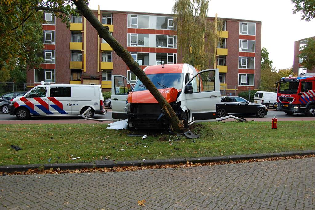 Bestelbus Postnl belandt met hoge snelheid tegen boom