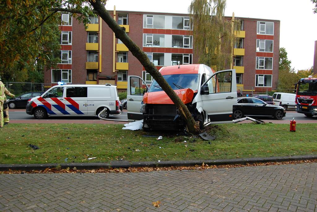 Bestelbus Postnl belandt met hoge snelheid tegen boom