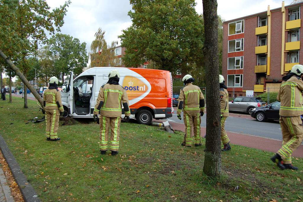 Bestelbus Postnl belandt met hoge snelheid tegen boom