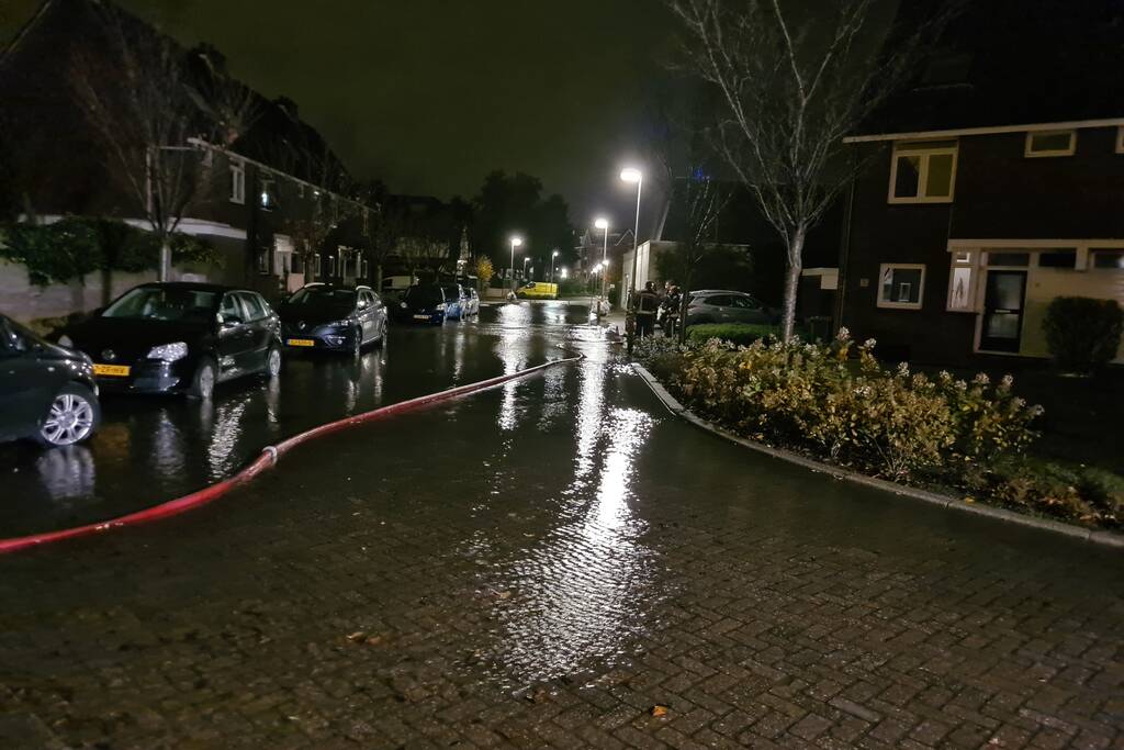 Straat onderwater door gesprongen hoofdwaterleiding