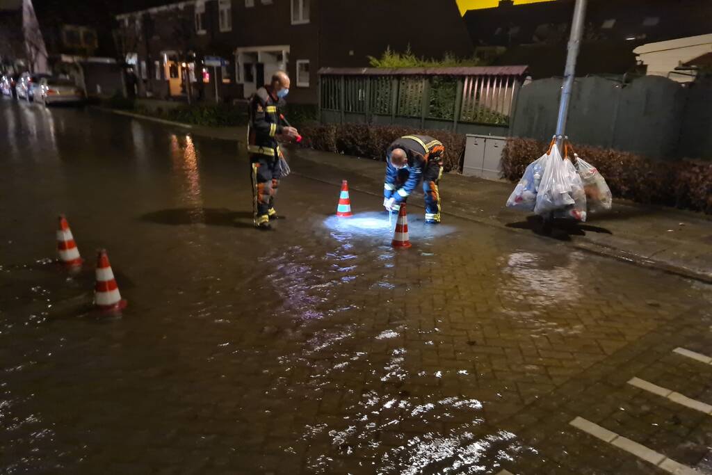 Straat onderwater door gesprongen hoofdwaterleiding