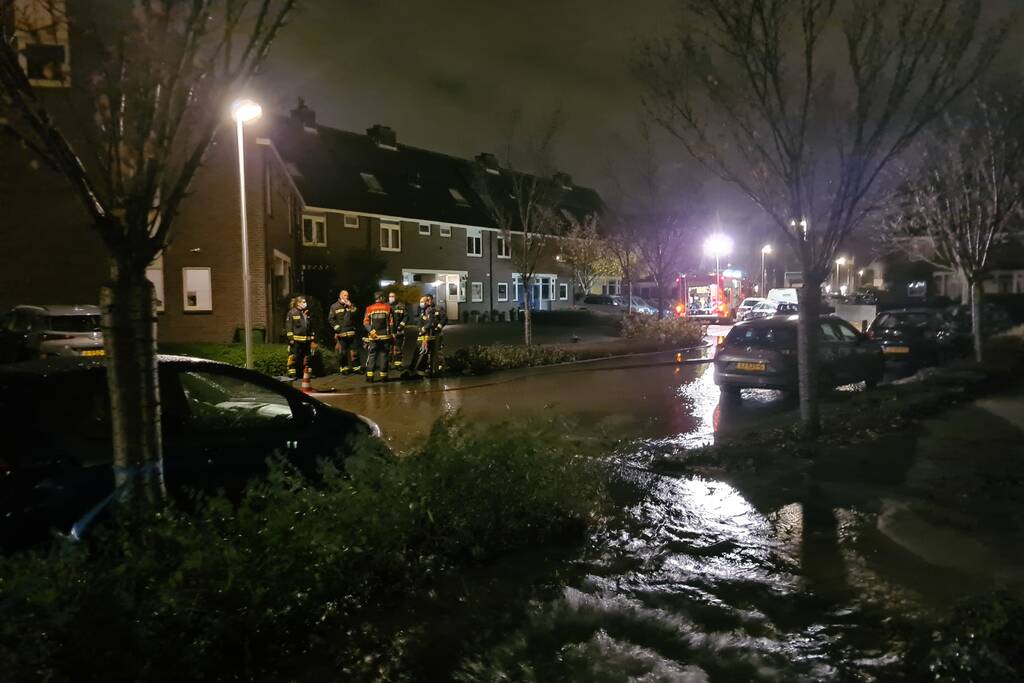 Straat onderwater door gesprongen hoofdwaterleiding