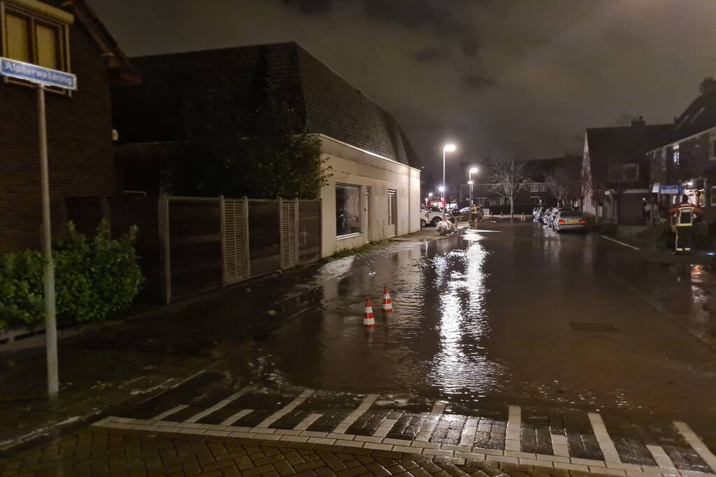 Straat onderwater door gesprongen hoofdwaterleiding