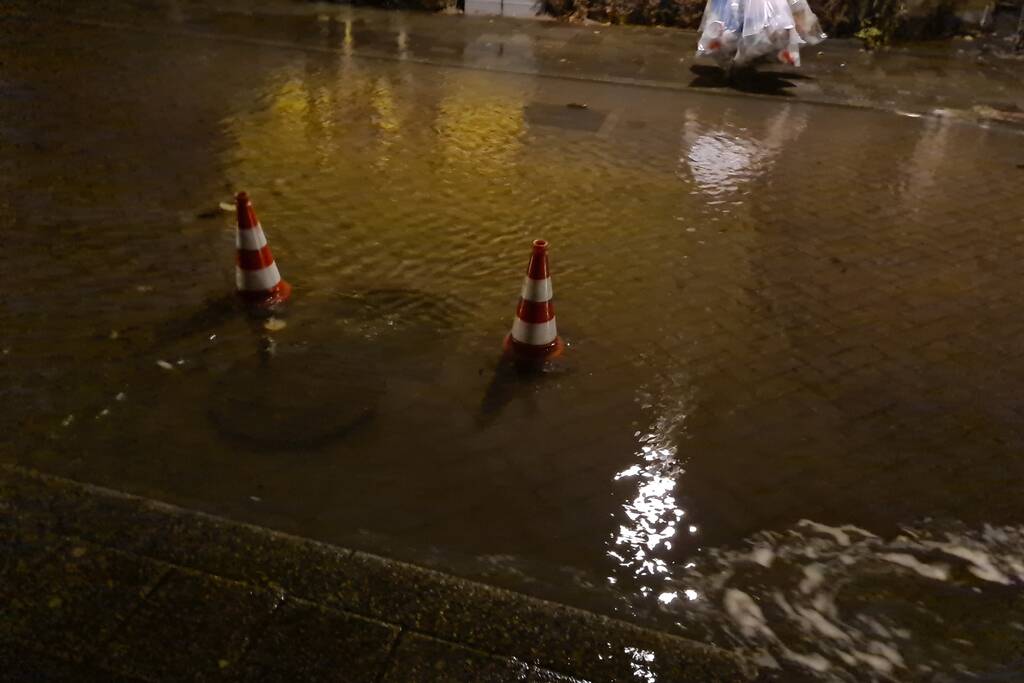 Straat onderwater door gesprongen hoofdwaterleiding