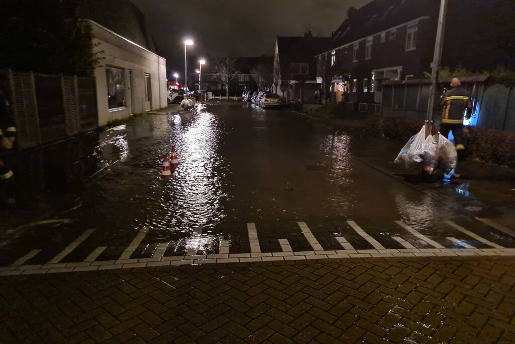 Straat onderwater door gesprongen hoofdwaterleiding