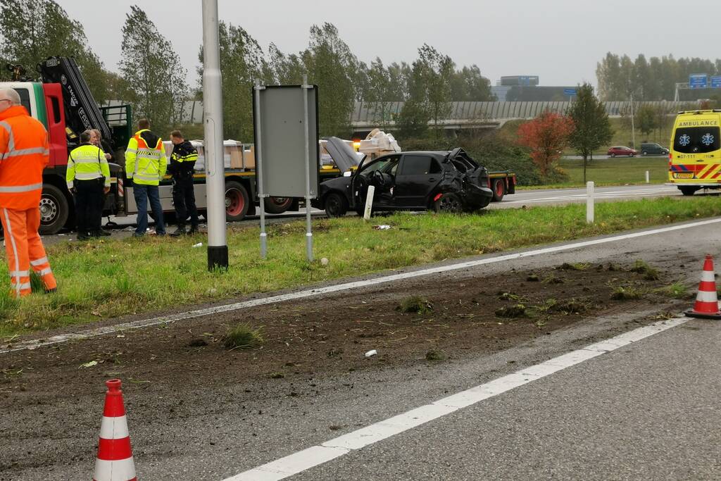 Auto van afrit geschoten, botst frontaal op vrachtwagen
