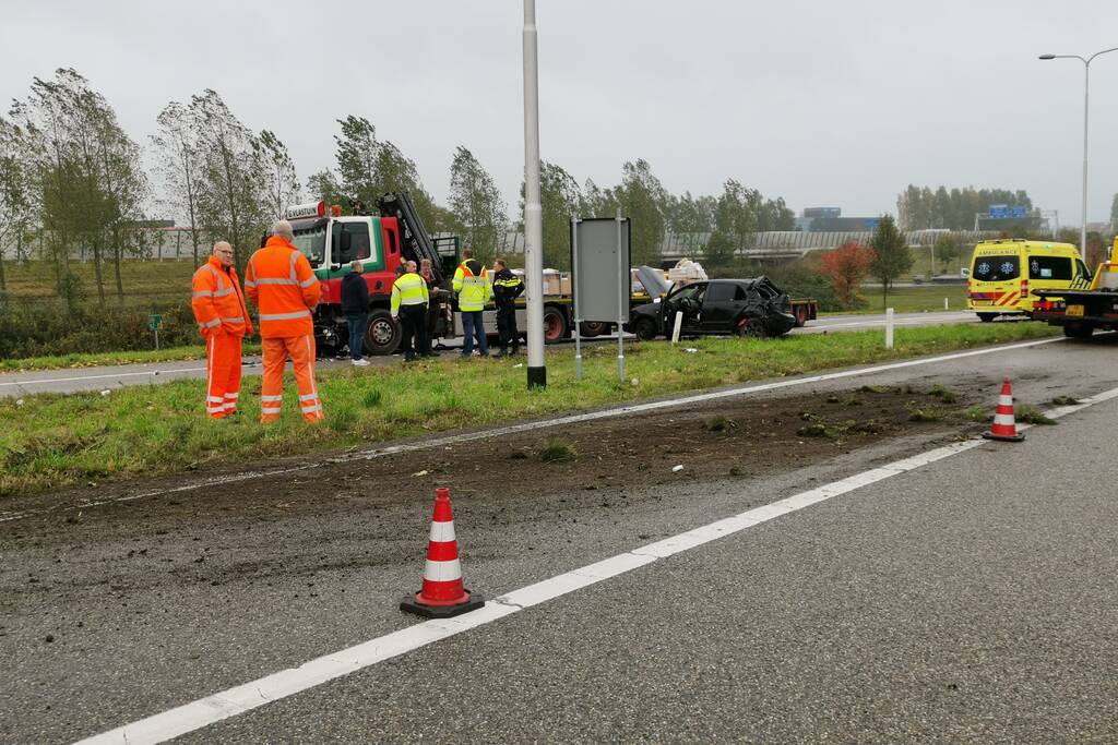 Auto van afrit geschoten, botst frontaal op vrachtwagen