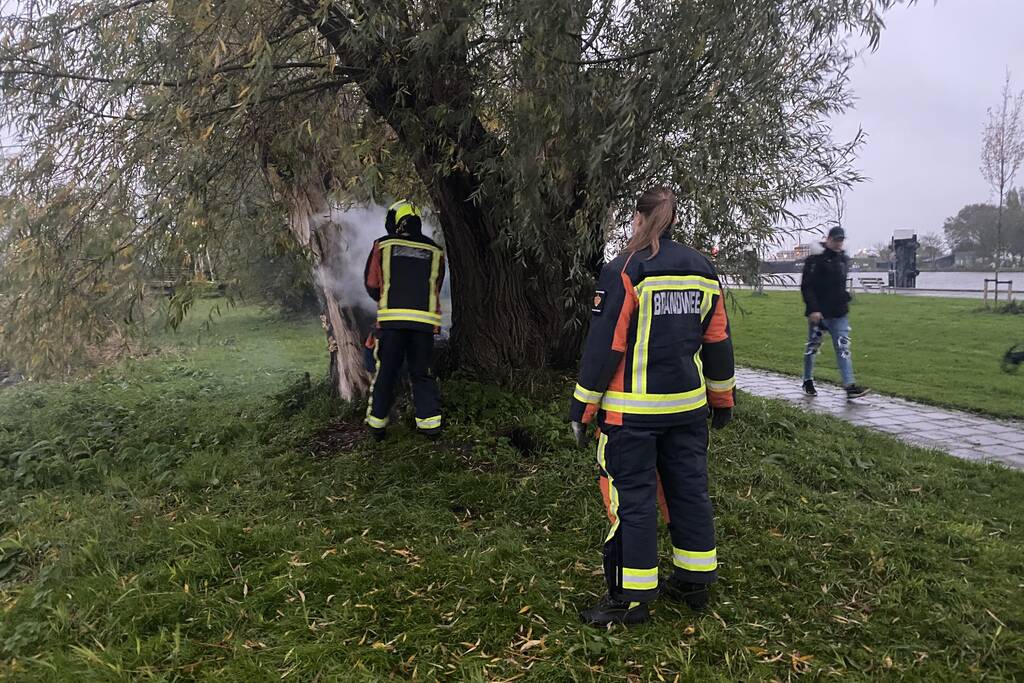 Brandweer blust brand in boom met emmer