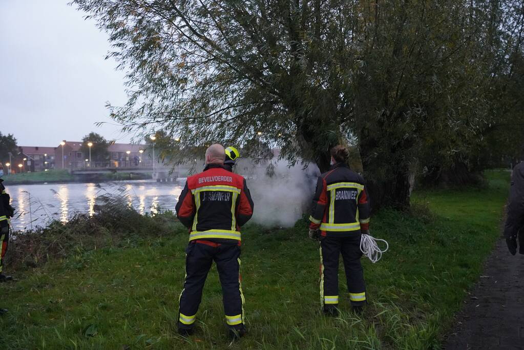 Brandweer blust brand in boom met emmer