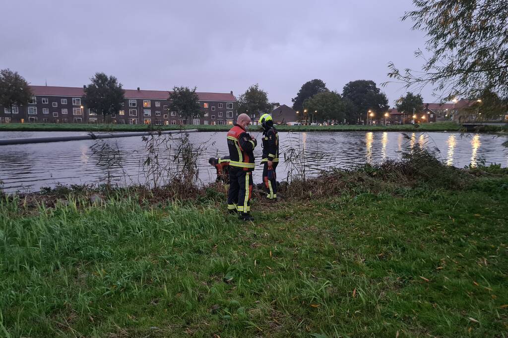 Brandweer blust brand in boom met emmer