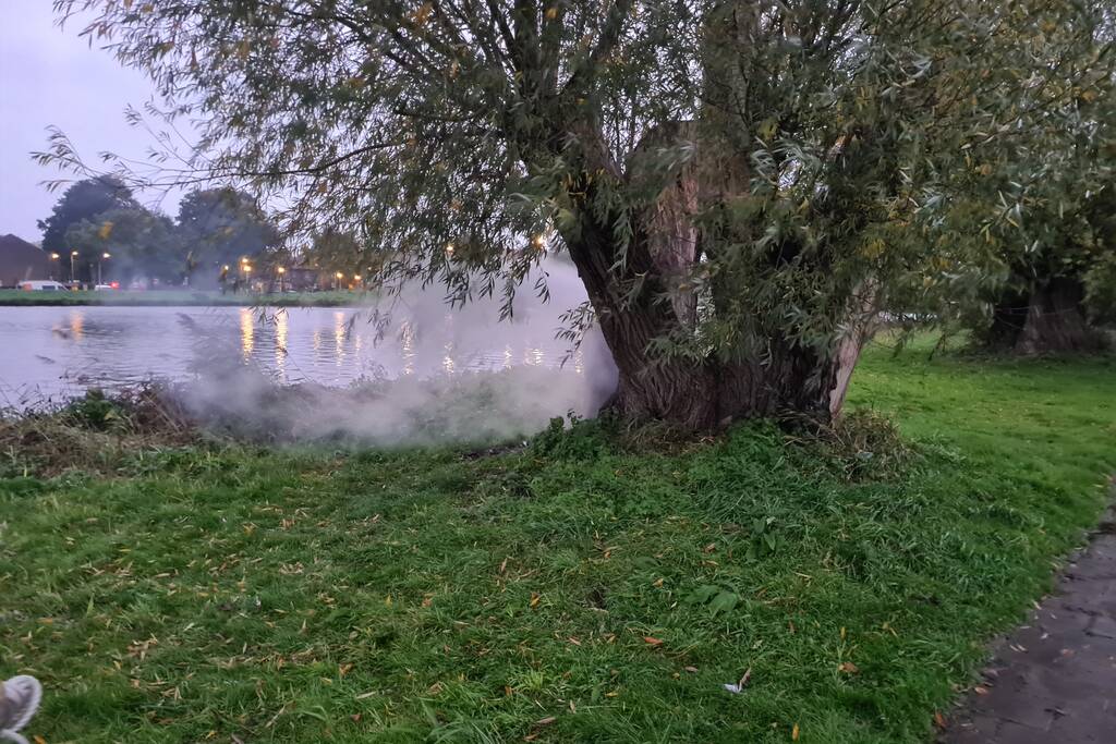 Brandweer blust brand in boom met emmer