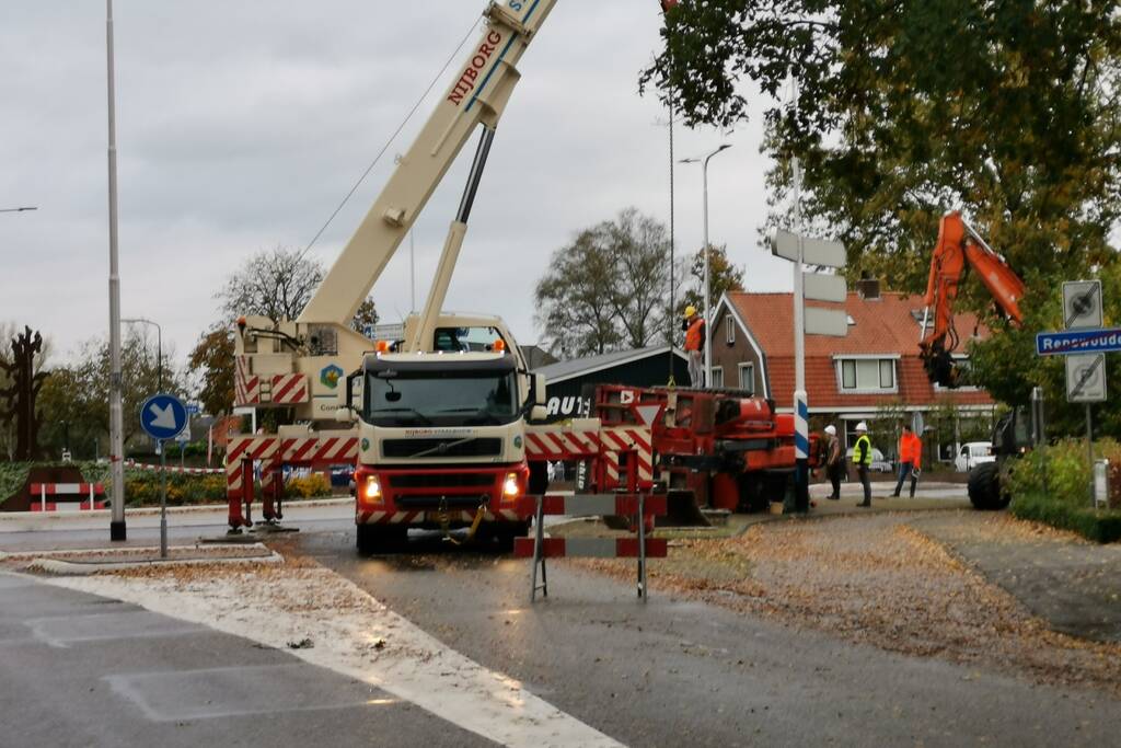 Grote aanhanger met verreiker op z'n kant op rotonde