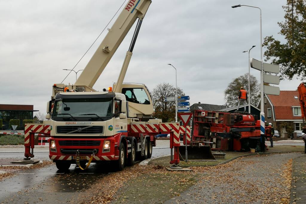 Grote aanhanger met verreiker op z'n kant op rotonde