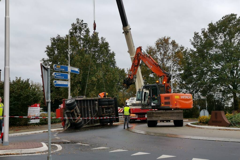 Grote aanhanger met verreiker op z'n kant op rotonde